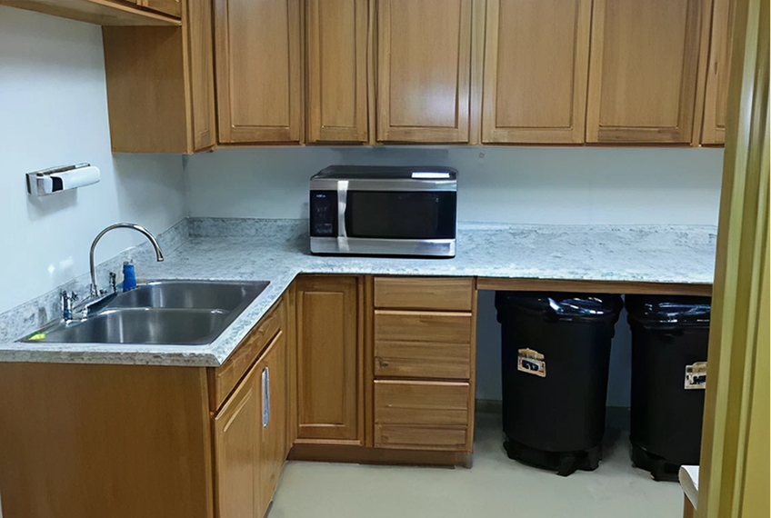 Kitchen area with sink and microwave oven.
