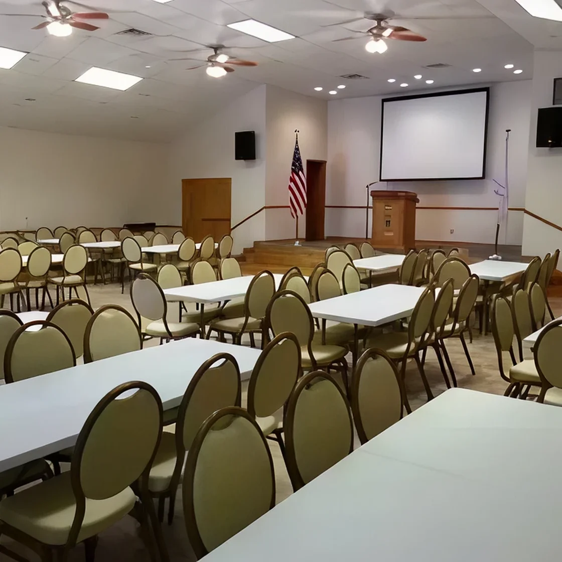 Empty conference room with arranged tables and chairs.